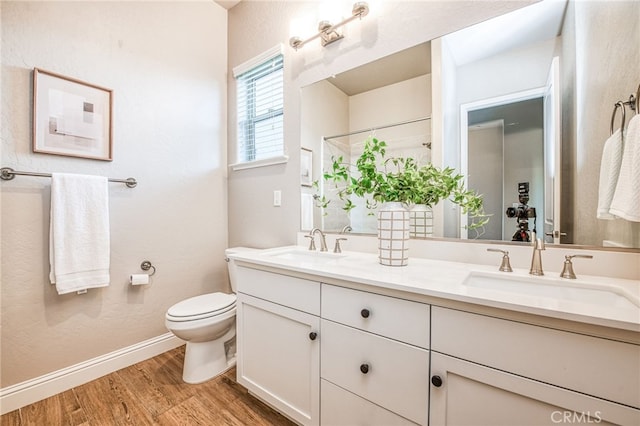 bathroom with wood-type flooring, toilet, and vanity