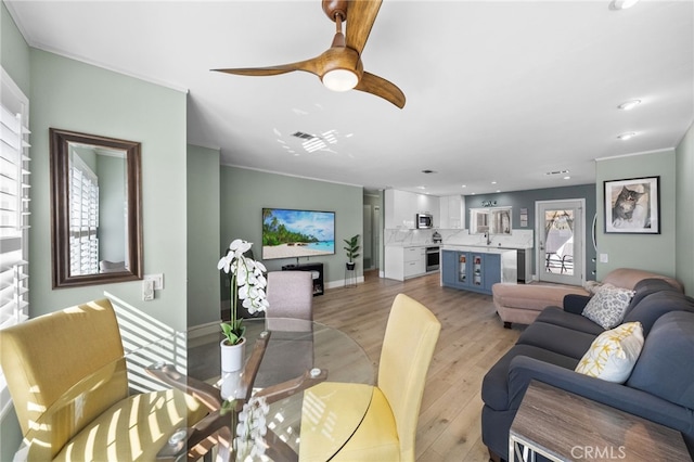 dining area with sink, light hardwood / wood-style flooring, and ceiling fan