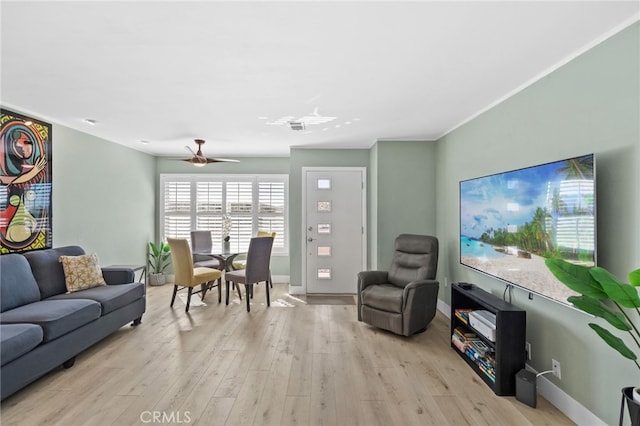 living room with crown molding, light hardwood / wood-style flooring, and ceiling fan