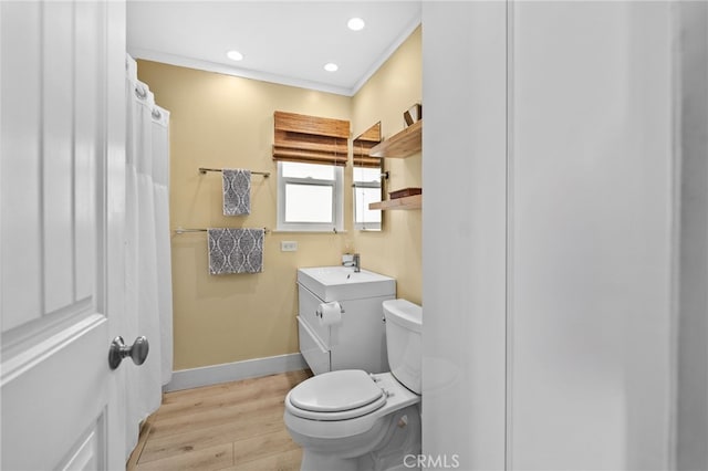 bathroom featuring hardwood / wood-style flooring, vanity, crown molding, and toilet