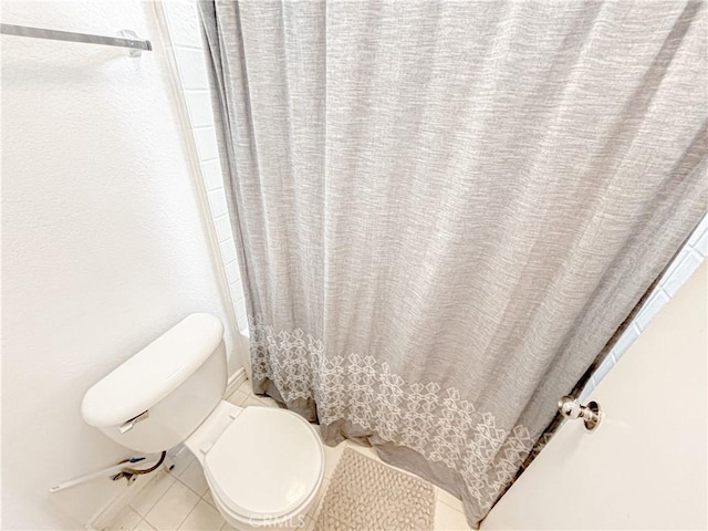 bathroom with tile patterned flooring, toilet, and walk in shower