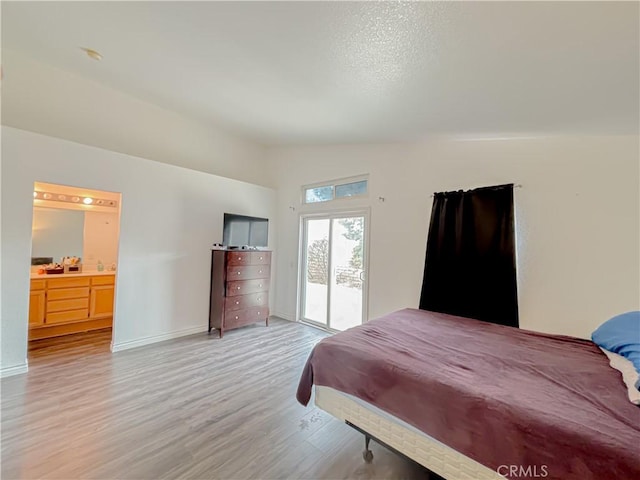 bedroom with light hardwood / wood-style flooring, vaulted ceiling, and access to exterior