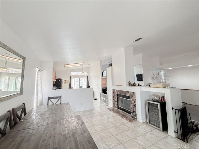 living room with a brick fireplace and wine cooler