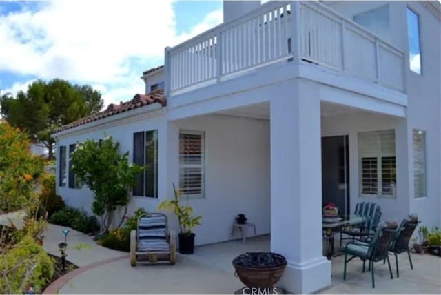 view of home's exterior with a patio area and a balcony