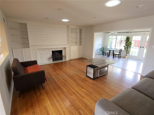 living room featuring built in shelves and light hardwood / wood-style floors