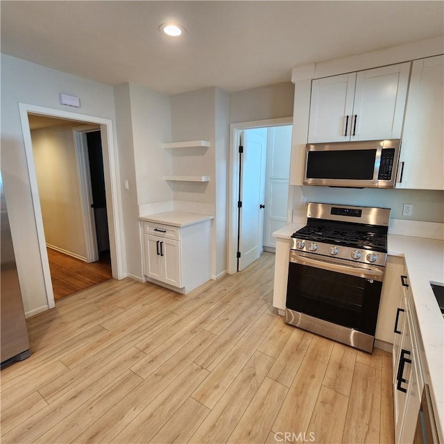 kitchen with white cabinetry, stainless steel appliances, and light wood-type flooring