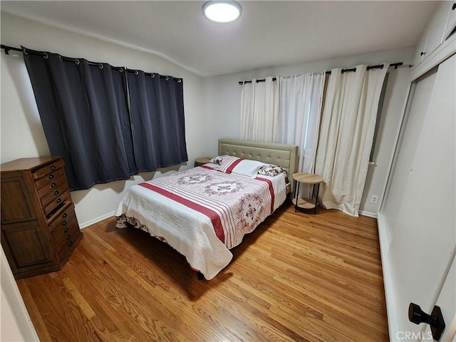 bedroom with hardwood / wood-style flooring and lofted ceiling