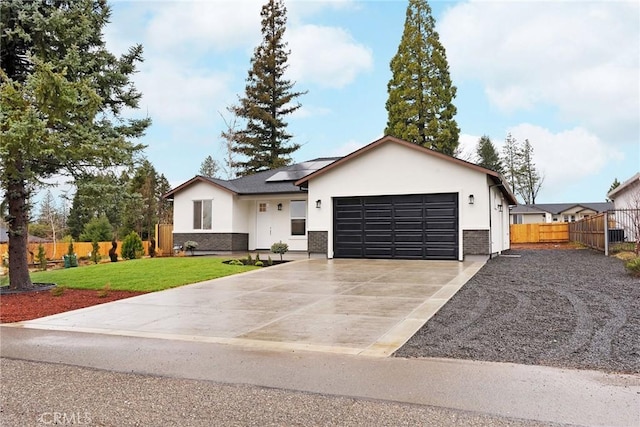 view of front of property featuring a garage, a front yard, and solar panels