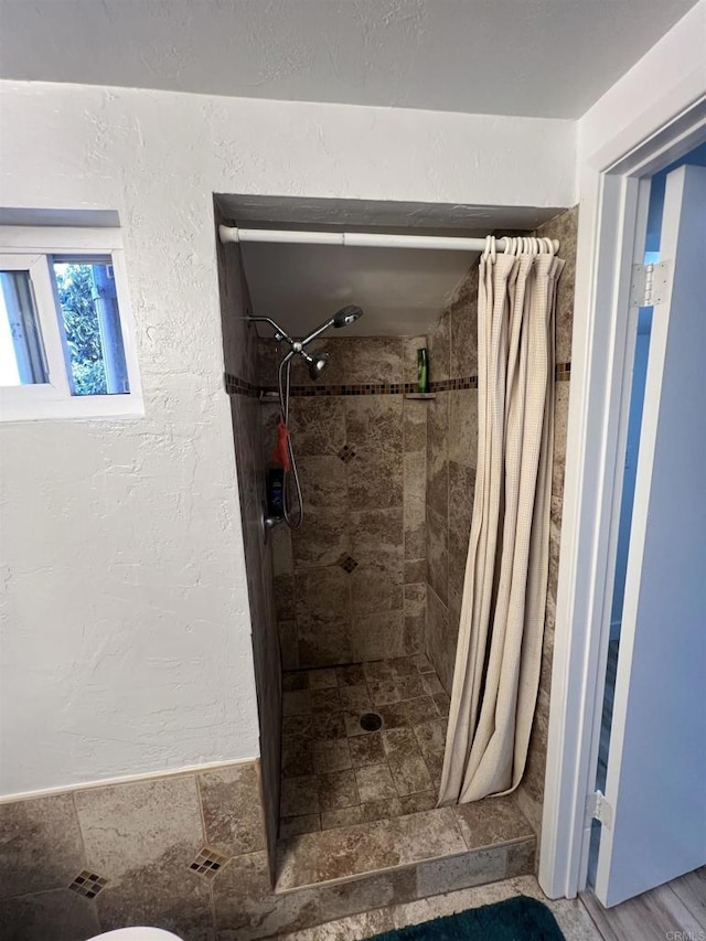 bathroom with toilet and a shower with shower curtain