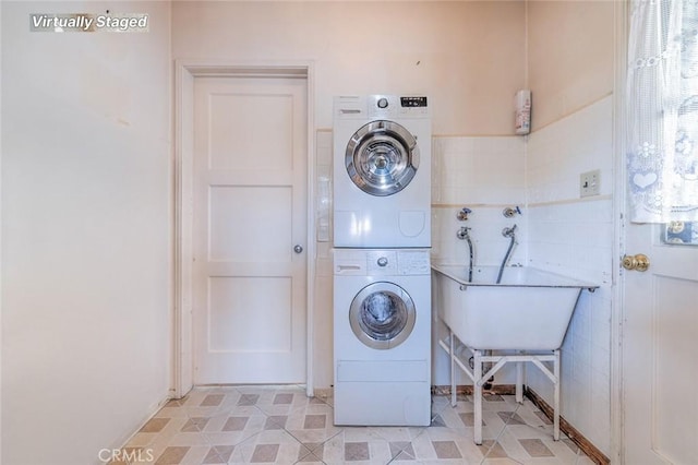 clothes washing area with stacked washer / dryer