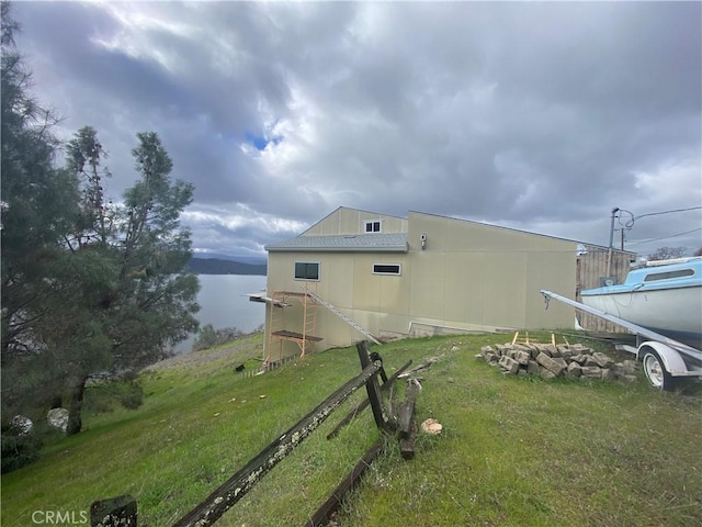 view of property exterior featuring a water view and a yard