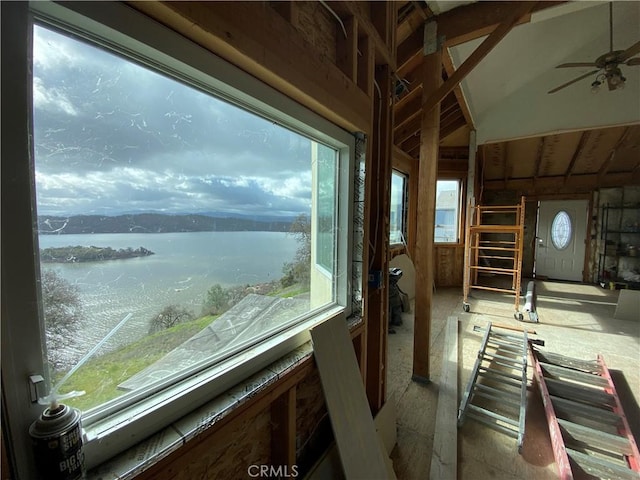 interior space with a water view, vaulted ceiling, and a ceiling fan