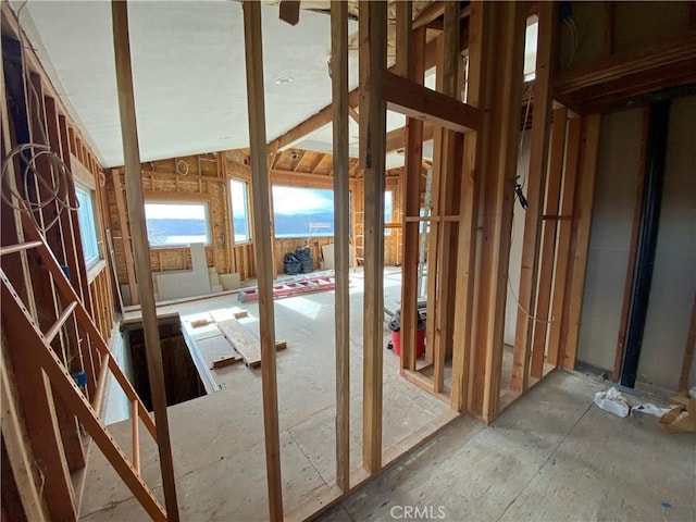 misc room with lofted ceiling and a water view