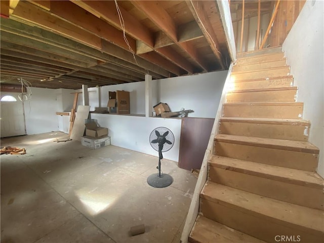 unfinished basement featuring stairs