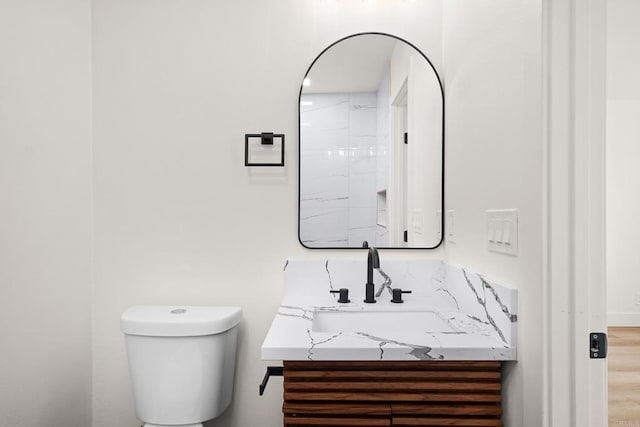 bathroom with hardwood / wood-style flooring, vanity, and toilet