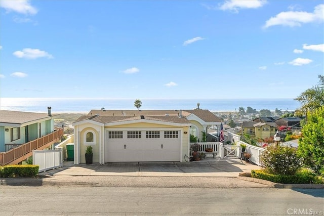 view of front facade featuring a garage, a water view, a gate, and fence