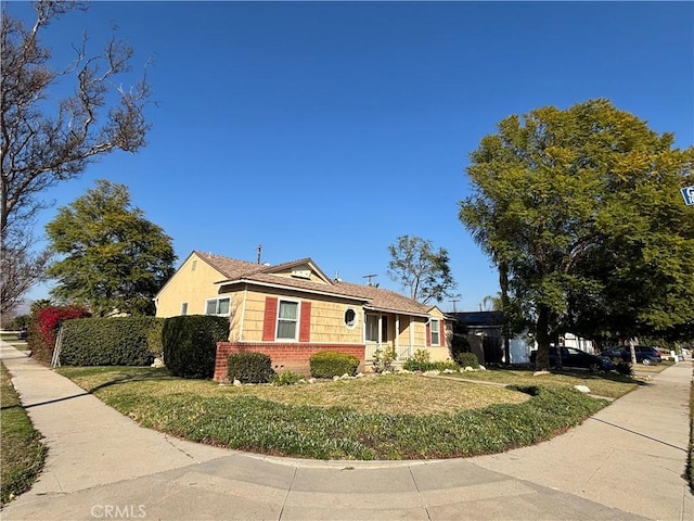 view of front of house with brick siding, a front yard, and fence