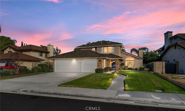 traditional-style house with stucco siding, concrete driveway, a garage, stone siding, and a front lawn