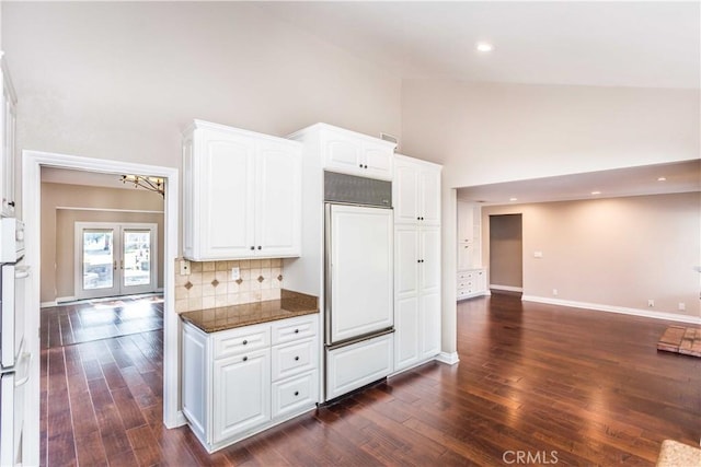 kitchen with french doors, dark wood finished floors, white cabinets, dark stone countertops, and high vaulted ceiling