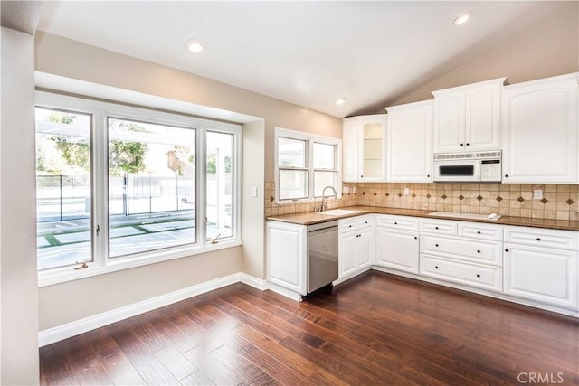 kitchen featuring tasteful backsplash, white microwave, glass insert cabinets, white cabinets, and dishwasher