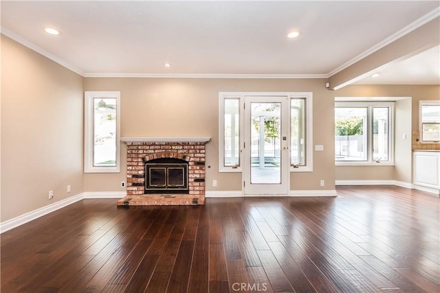 unfurnished living room with baseboards, dark wood-style floors, ornamental molding, a fireplace, and recessed lighting