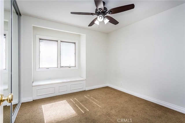 interior space with carpet floors, baseboards, and a ceiling fan