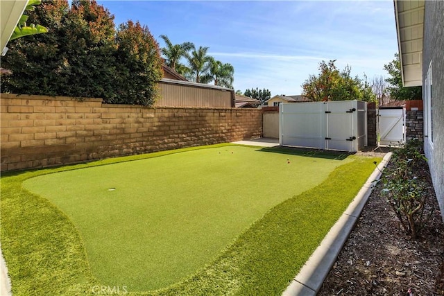 view of yard featuring a fenced backyard and a gate