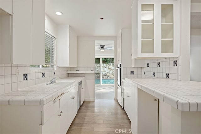 kitchen featuring sink, white cabinetry, and tile countertops