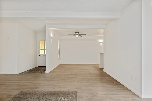 interior space featuring ceiling fan, beamed ceiling, a textured ceiling, and light hardwood / wood-style floors