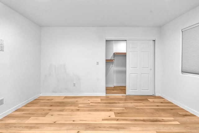 unfurnished bedroom with a closet and light hardwood / wood-style flooring