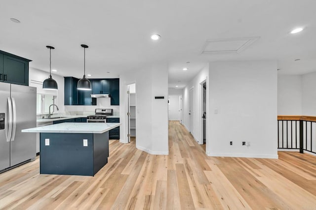 kitchen featuring stainless steel appliances, light stone counters, decorative light fixtures, a kitchen island, and sink