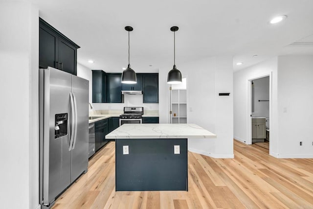 kitchen featuring a center island, light stone countertops, sink, appliances with stainless steel finishes, and pendant lighting