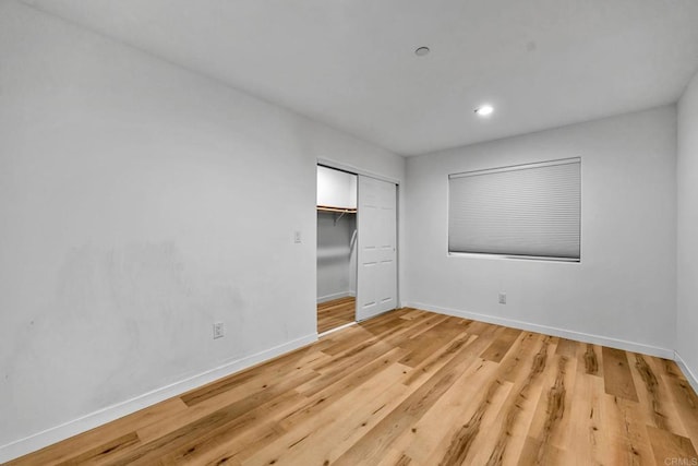 unfurnished bedroom with light hardwood / wood-style floors and a closet