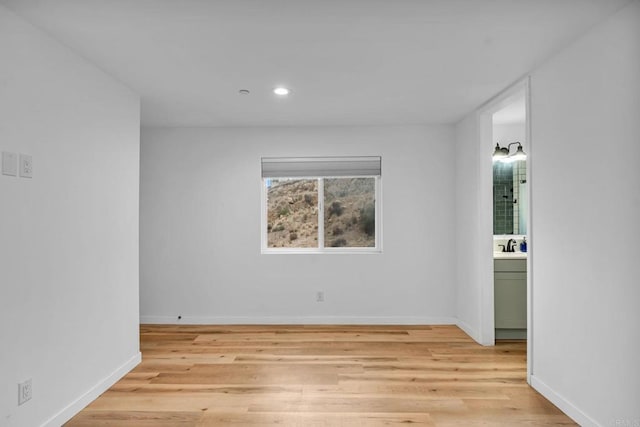 unfurnished room with sink and light hardwood / wood-style floors