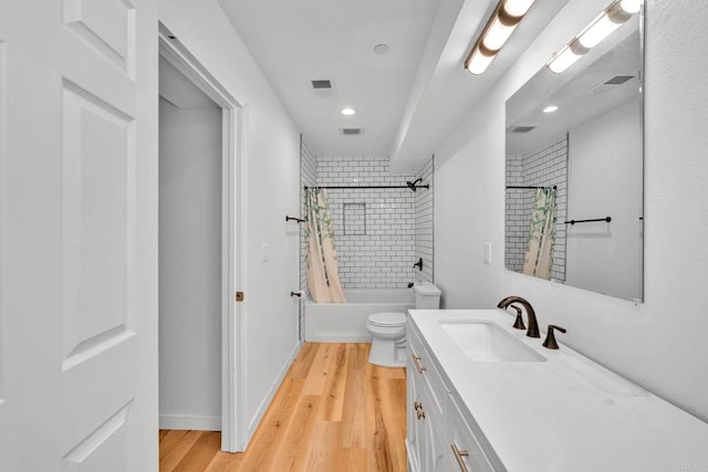 full bathroom with hardwood / wood-style floors, vanity, toilet, and shower / bath combo with shower curtain