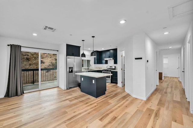 kitchen featuring appliances with stainless steel finishes, sink, light hardwood / wood-style flooring, a kitchen island, and decorative light fixtures