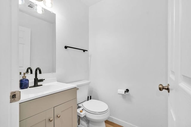 bathroom with hardwood / wood-style flooring, toilet, and vanity