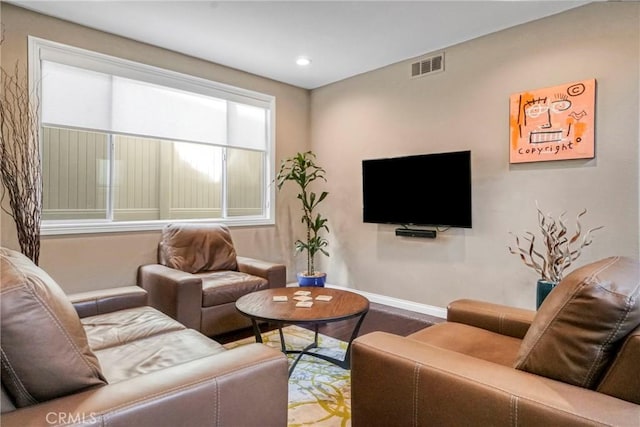 living room with baseboards, visible vents, and recessed lighting