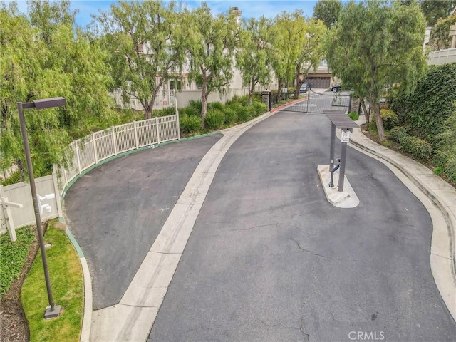 view of street featuring curbs, a gated entry, and a gate