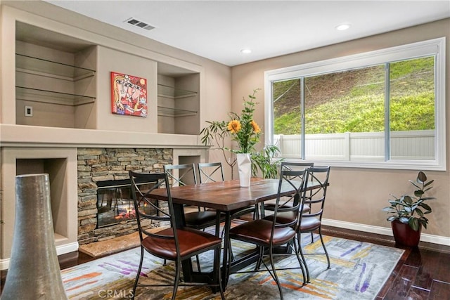 dining area featuring recessed lighting, dark wood-type flooring, a fireplace, visible vents, and baseboards