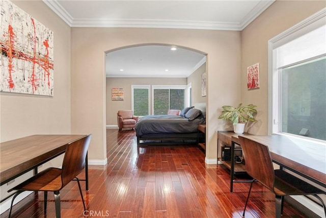 bedroom featuring arched walkways, ornamental molding, dark wood finished floors, and baseboards