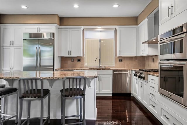 kitchen featuring stainless steel appliances, light stone counters, and a breakfast bar