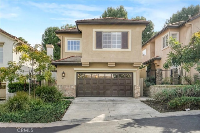 view of front facade featuring concrete driveway, brick siding, an attached garage, and stucco siding