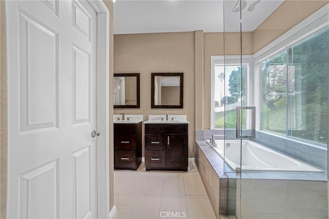 bathroom featuring a sink, double vanity, a garden tub, and tile patterned floors