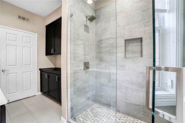 full bath with a stall shower, tile patterned flooring, visible vents, and vanity