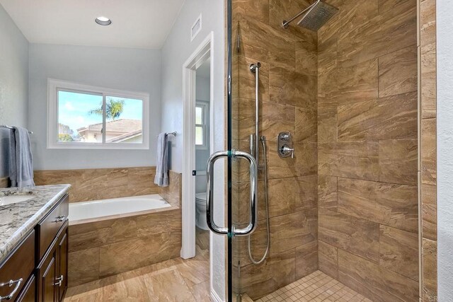 bathroom with vanity, visible vents, a shower stall, a garden tub, and toilet