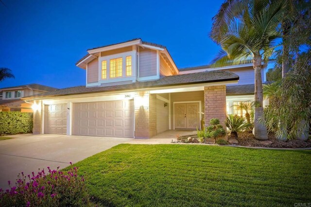 traditional home with a front lawn, concrete driveway, and brick siding