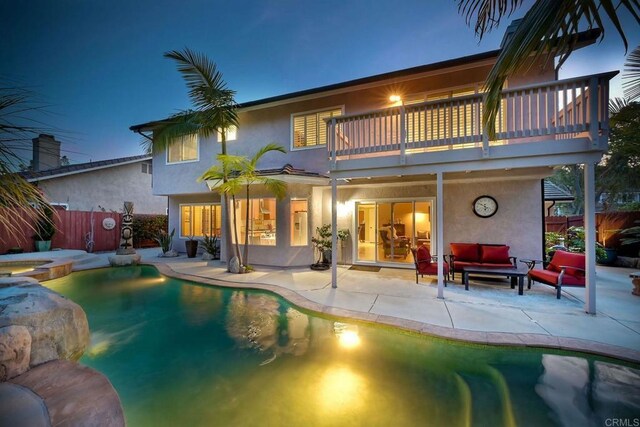 rear view of property with stucco siding, a patio, outdoor lounge area, and fence