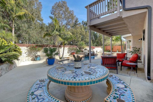 view of patio with a balcony and a fenced backyard