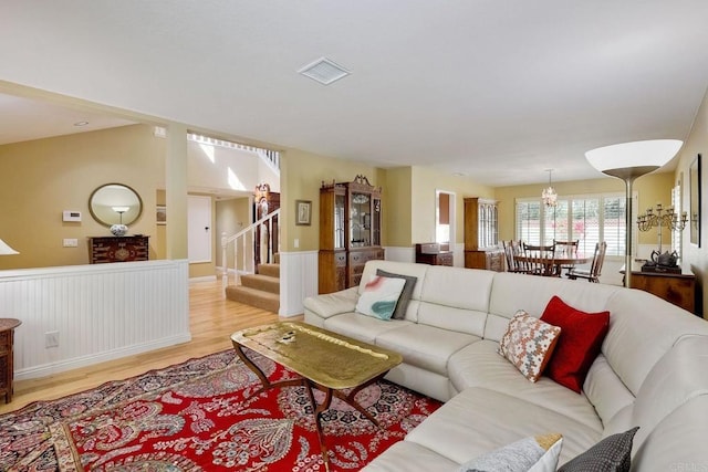 living area featuring stairs, visible vents, and light wood finished floors